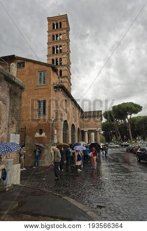 Rome Italy - October 1 2015: Basilica Santa Maria in Cosmedin and Fontana dei Tritoni in piazza Bocca della Verità with crowds and traffic surrounding it.