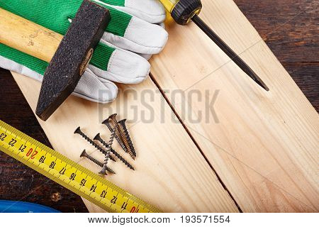 Working tools carpenter on a wooden background - ruler nails working gloves pliers. carpentry