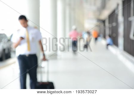 Blur image of flight crew and people walking in airport corridor