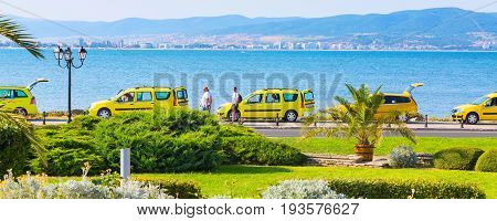 Nessebar, Bulgaria - July 25, 2016: Row of yellow taxi cars and Black sea coast in Nesebar in Bulgaria