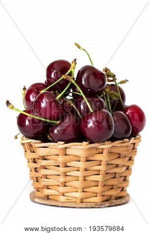 Full basket of red cherries on a stem close up isolated on white background