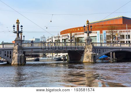 Amsterdam, Netherlands - April 2, 2016: Opera house, canal and bridge panorama in Holland
