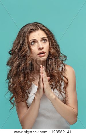 The Woman is looking imploring over gray studio background