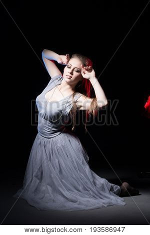 Actress In A Grey Dress On A Dark Stage