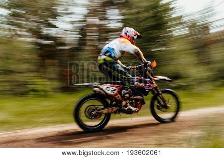 blurred motion athlete bike enduro in forest trial racing motocross