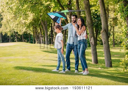 Family Launching Kite While Spending Time Together In Park