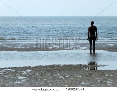 statue facing the sea at crosby beach merseyside