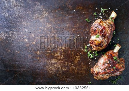 Two Barbecue Leg of Lamb as top view on old rusty metal sheet 