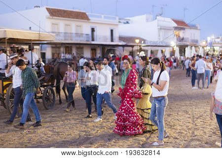 El Rocio Spain - June 2 2017: Pilgrims in traditional flamenco dresses in El Rocio during the pilgrimage Romeria 2017. Province of Huelva Andalusia Spain