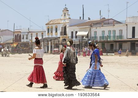 El Rocio Spain - June 2 2017: Female pilgrims in traditional flamenco dresses in El Rocio during the pilgrimage Romeria 2017. Province of Huelva Andalusia Spain