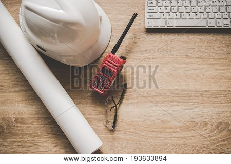 Engineering tools on work table for construction project. With a white helmet raido and blueprints. Safety control. Engineer Concept.