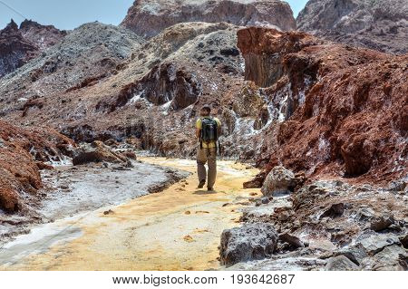 Hormuz Island Hormozgan Province Iran - 17 april 2017: Iranian Island of Hormuz in Persian Gulf One traveler walks along the yellow river in the salt valley.