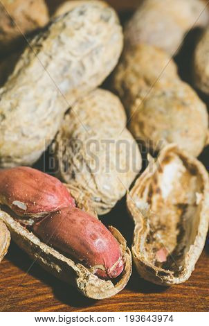 Peanuts in shell on dark wooden background. Close up. Selective focus. Vertical image. Peanuts view from above.