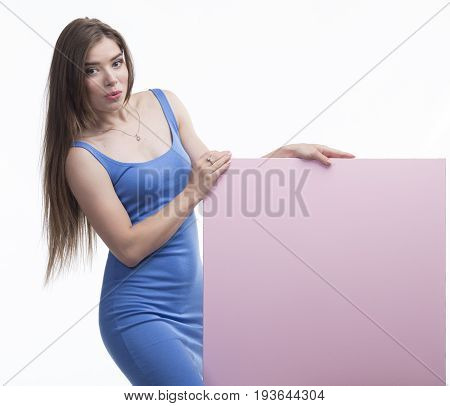 Young jocular woman portrait of a confident businesswoman showing presentation, pointing placard pink background. Ideal for banners, registration forms, presentation, landings, presenting concept.