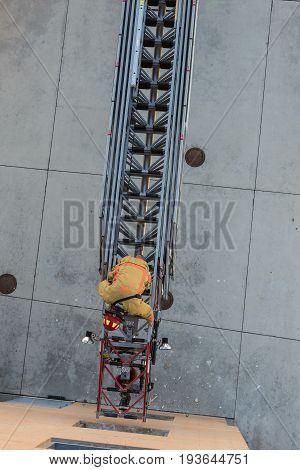 Firefighter Training Entering And Exiting A Building On A Truck Ladder Overhead View