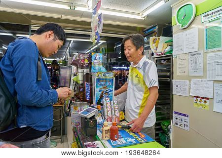 SEOUL, SOUTH KOREA - CIRCA MAY, 2017: man paying at CU convenience store. CU is a convenience store franchise chain in South Korea.