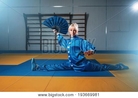 Female wushu master exercise with fan, martial art