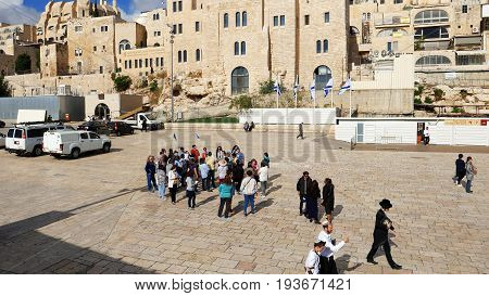 Jerusalem, Israel - May 21, 2017: Group of tourists with guide going to visit the Western wall in Jerusalem. Wailing Wall or Kotel is the most sacred place for all jews and christians on the planet.