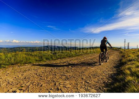 Mountain biking women riding on bike in summer mountains forest landscape. Woman cycling MTB flow trail track. Outdoor sport activity.