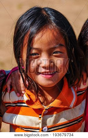 MUANG SING, LAOS - DECEMBER 28, 2012: Local girl in a small ethnic community near the village of Muang Sing in Laos