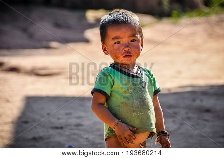 MUANG SING, LAOS - DECEMBER 28, 2012: Local boy in a small ethnic community near the village of Muang Sing in Laos