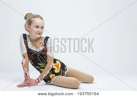 Sport Ideas. Young Smiling Caucasian Female Rhythmic Gymnast Athlete In Professional Competitive Suit Posing in Studio Against White.Horizontal Image