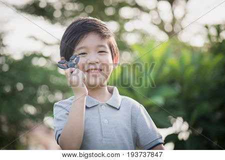 Chld  Playing  Fidget Spinner On Nature Background