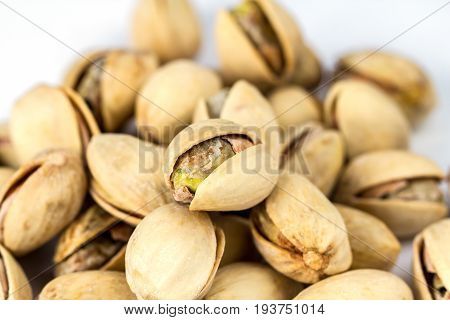 Salt pistachio nuts pile isolated on white background close up, macro