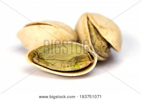 Three salt pistachio nuts isolated on white backround close up, macro