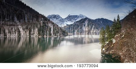 Mountain lake against the backdrop of snow-capped mountains. Rizza Abkhazia