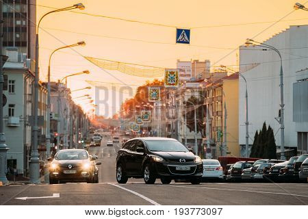 Gomel, Belarus  - July 30, 2016: Traffic On Lenin Avenue On The Sunset With Moving Black Mazda CX-7 Car, Compact Crossover SUV Foreground. View Of Central City Street Going Straight To Lenin Square