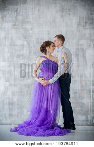 pregnant woman and man posing together in Studio, happy waiting