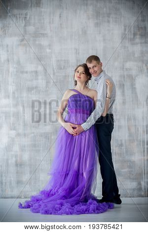 pregnant woman and man posing together in Studio, happy waiting