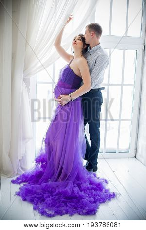 pregnant woman and man posing together in Studio, happy waiting