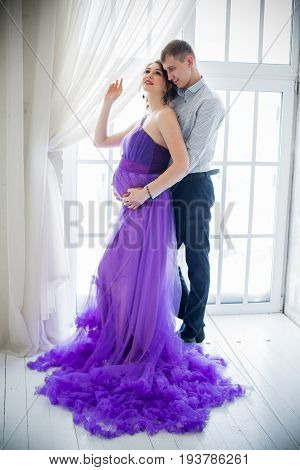 pregnant woman and man posing together in Studio, happy waiting