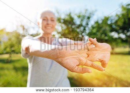 Trin your hands. Close up of hands of positive smilingged woman holding them together and expressing gladness while doing sport exercises