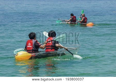 Labuan,Malaysia-May 1,2017:Group of tourist enjoying a weekend kayaking with the transparent kayak in Rusukan Besar island,Labuan,Malaysia.Labuan is the ideal place for water sports,like kayaking & scuba diving