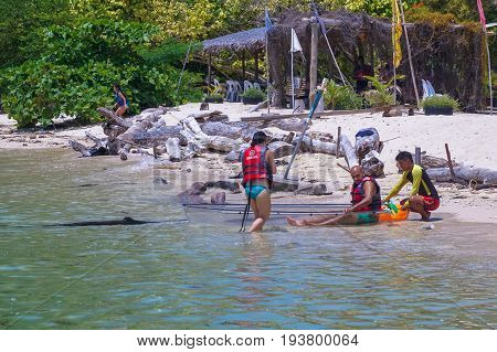 Labuan,Malaysia-May 1,2017:Group of tourist enjoying a weekend kayaking with the transparent kayak in Rusukan Besar island,Labuan,Malaysia.Labuan is the ideal place for water sports,like kayaking & scuba diving