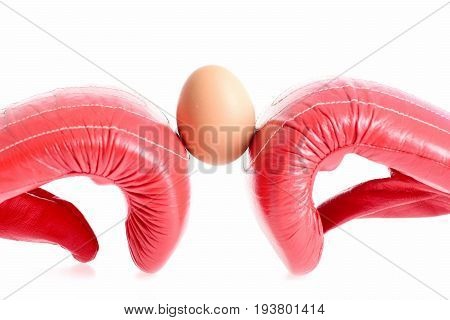 Professional box fight and dieting concept. Sport equipment and food isolated on white background. Boxing gloves in red color. Pair of leather boxing sportswear with brown egg in between