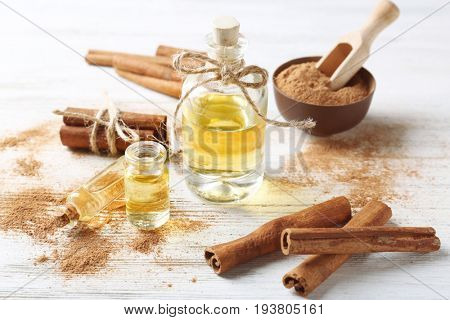 Composition with bottles of cinnamon oil on wooden background