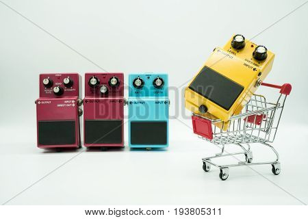 Group of vintage guitar pedals and shopping cart isolated on white background
