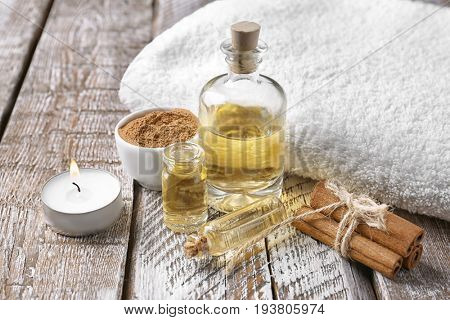 Composition with bottles of cinnamon oil on wooden background