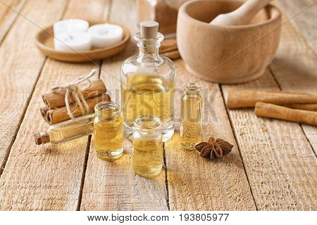 Composition with bottles of cinnamon oil on wooden background