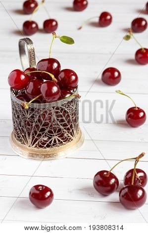 Fresh cherry on plate on wooden background and fresh ripe cherries