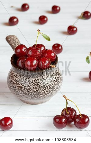 Fresh cherry on plate on wooden background and fresh ripe cherries