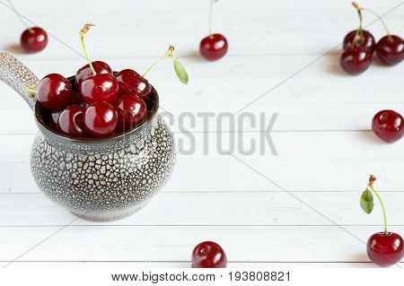Fresh cherry on plate on wooden background and fresh ripe cherries