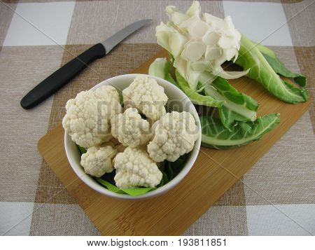 Cleaned fresh white cauliflower on a wooden board