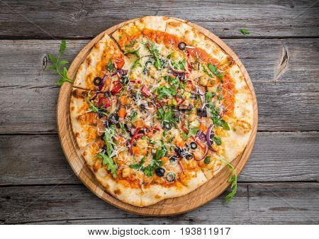 Delicious Italian pizza with vegetables on a wooden table