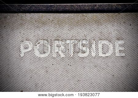 The word Portside printed on textured surface on dock