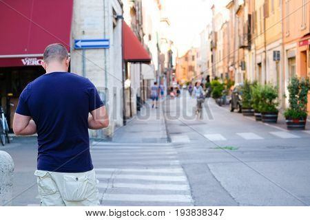 Ferrara, Italy - June, 30, 2017: pedestrian crosses on a street in a center of Ferrara, Italy